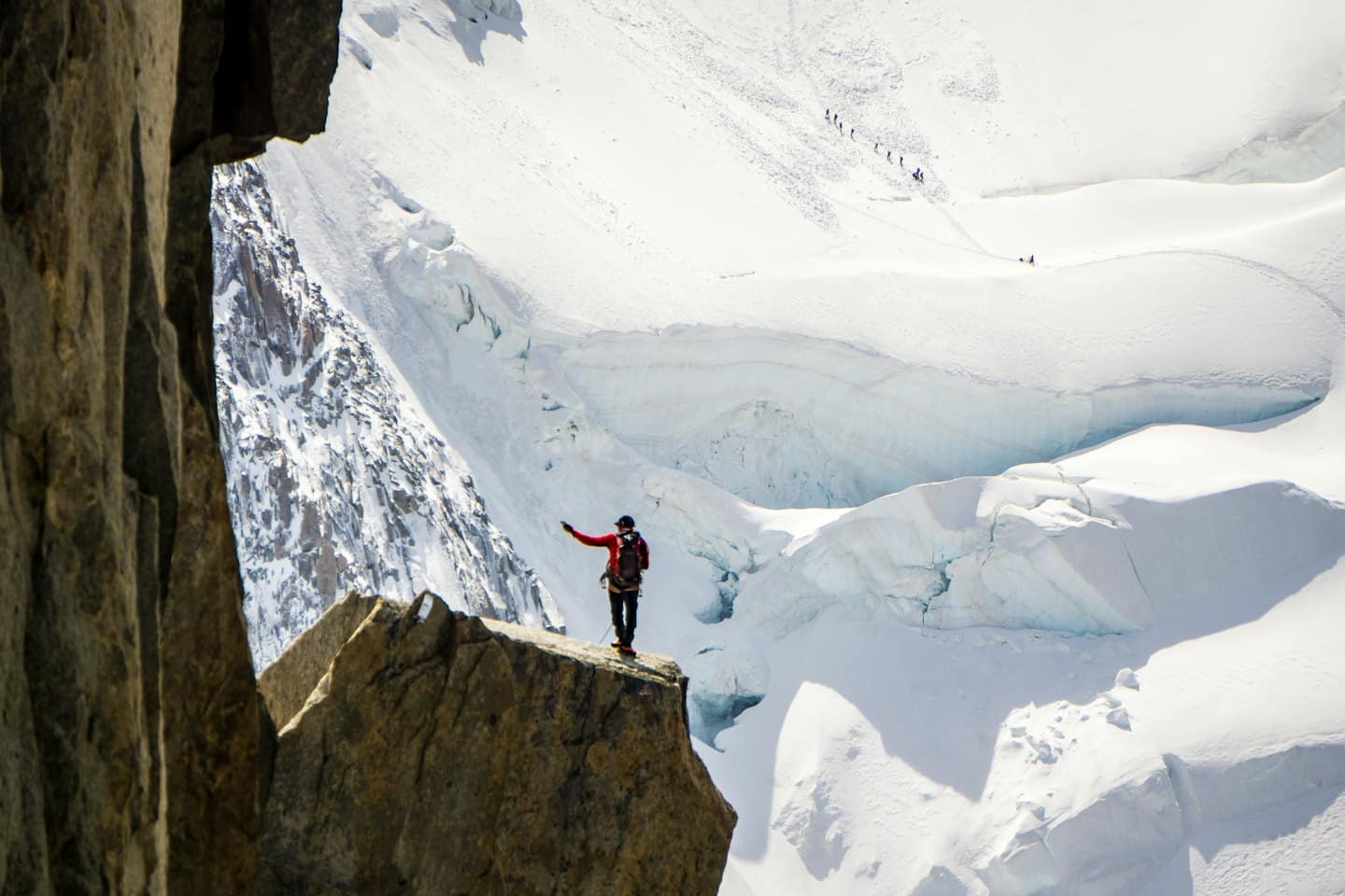 ALPINIST KARDA TIRMANIŞ YAPANLARI İŞARET EDİYOR.